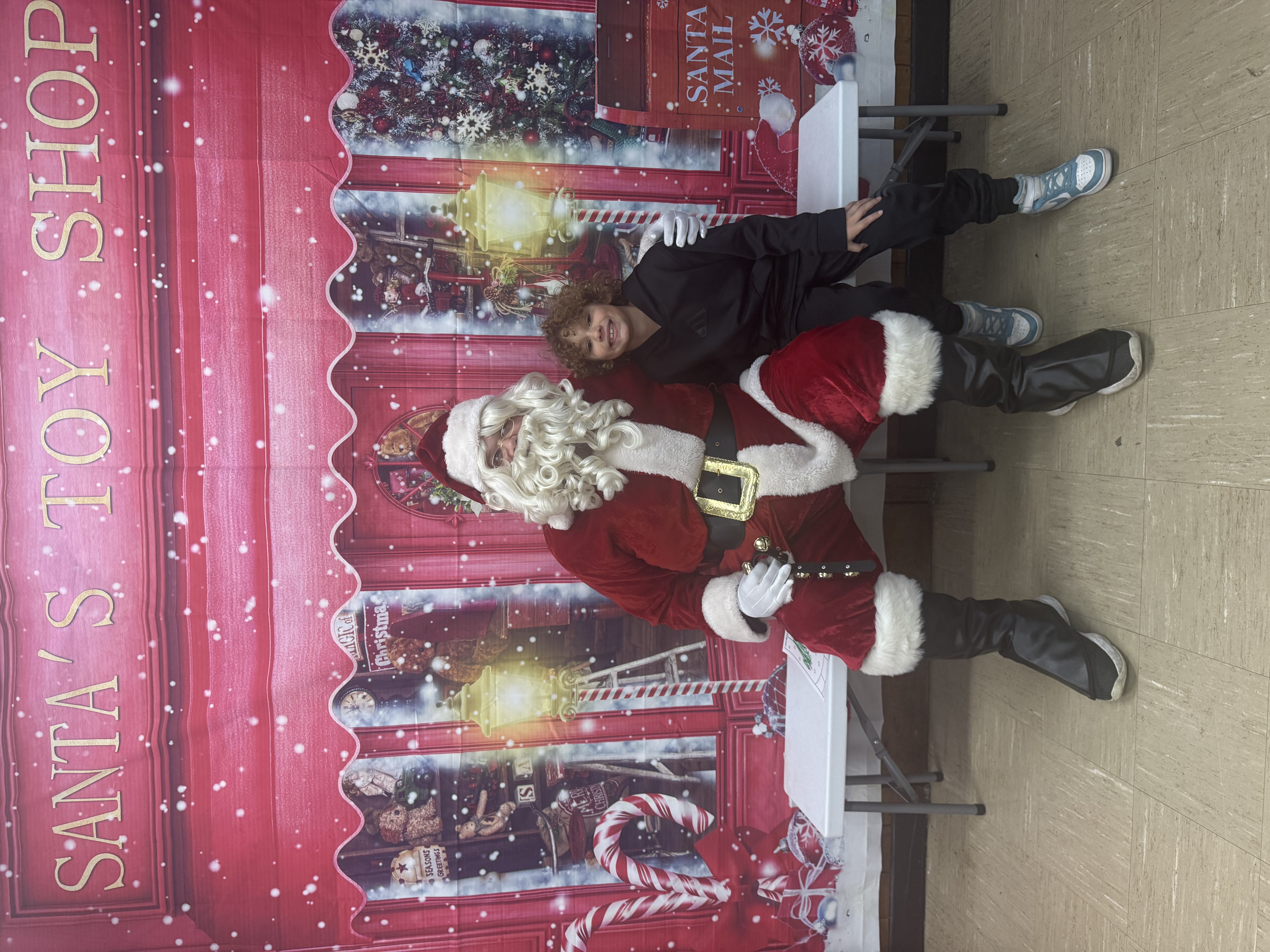 A boy with Santa at a toy shop background.